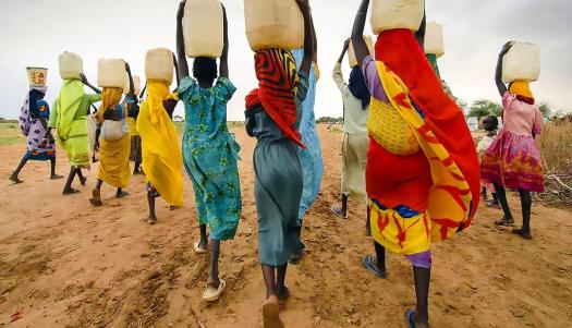 Women carrying water on their heads, near the city of Tanzania, Dar Es Salaam. Image by RM Photography.