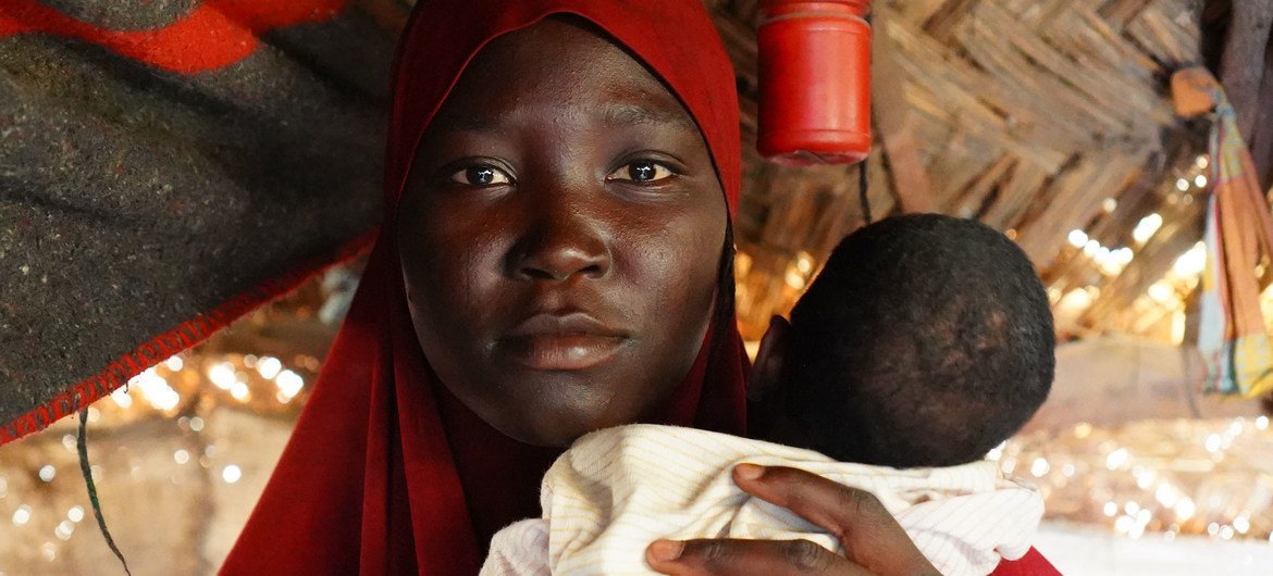 UNOCHA/Eve Sabbagh A women hold her baby in a cap for displaced people in Maiduguri in northeastern Nigeria.