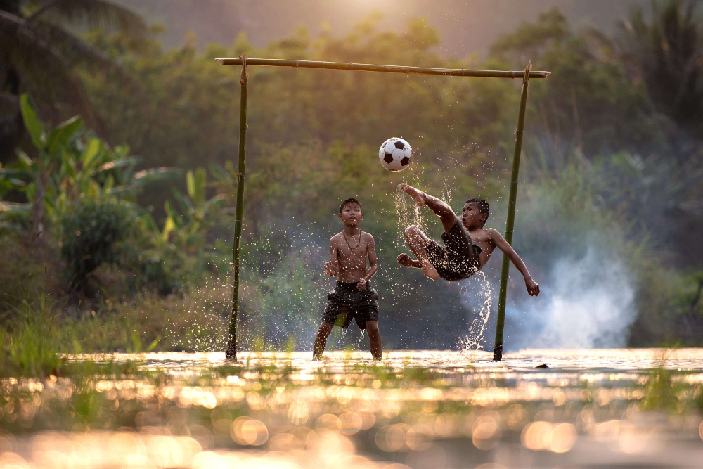 Boys playing football (soccer). Photo by VietNam Beautiful on Unsplash