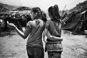 Two girls walk through a camp