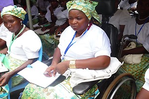 Image of African woman in a wheelchair with papers on her lap