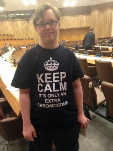 Image of young boy at UN Headquarters attending the World Down Syndrome Day Conference with T-shirt that says "Keep calm: It's only an extra chromosome"