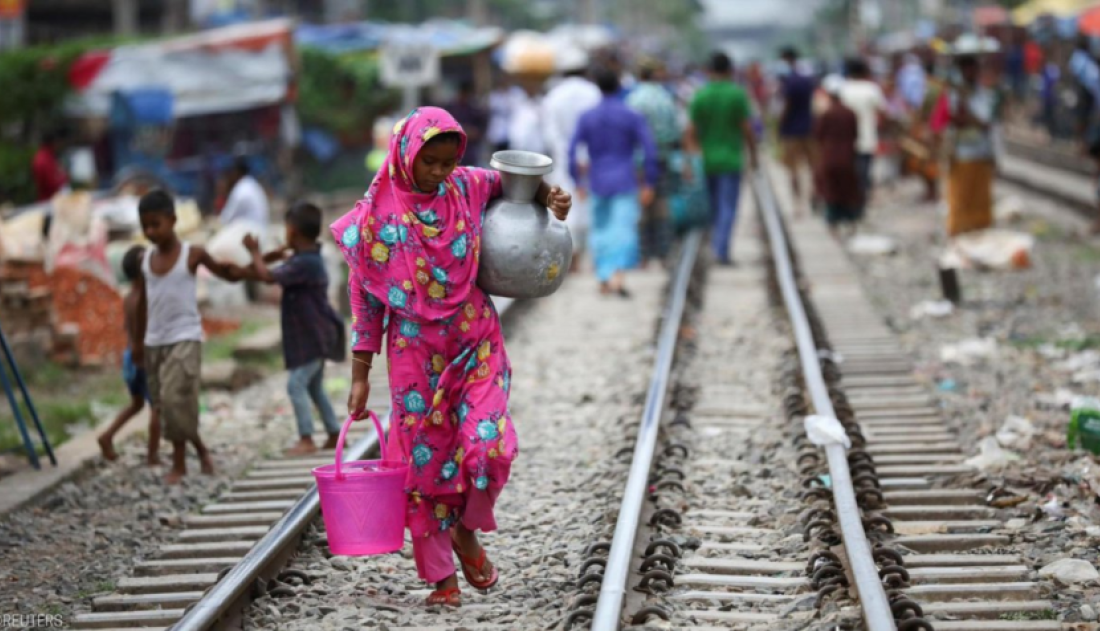 Woman walking along a railway line