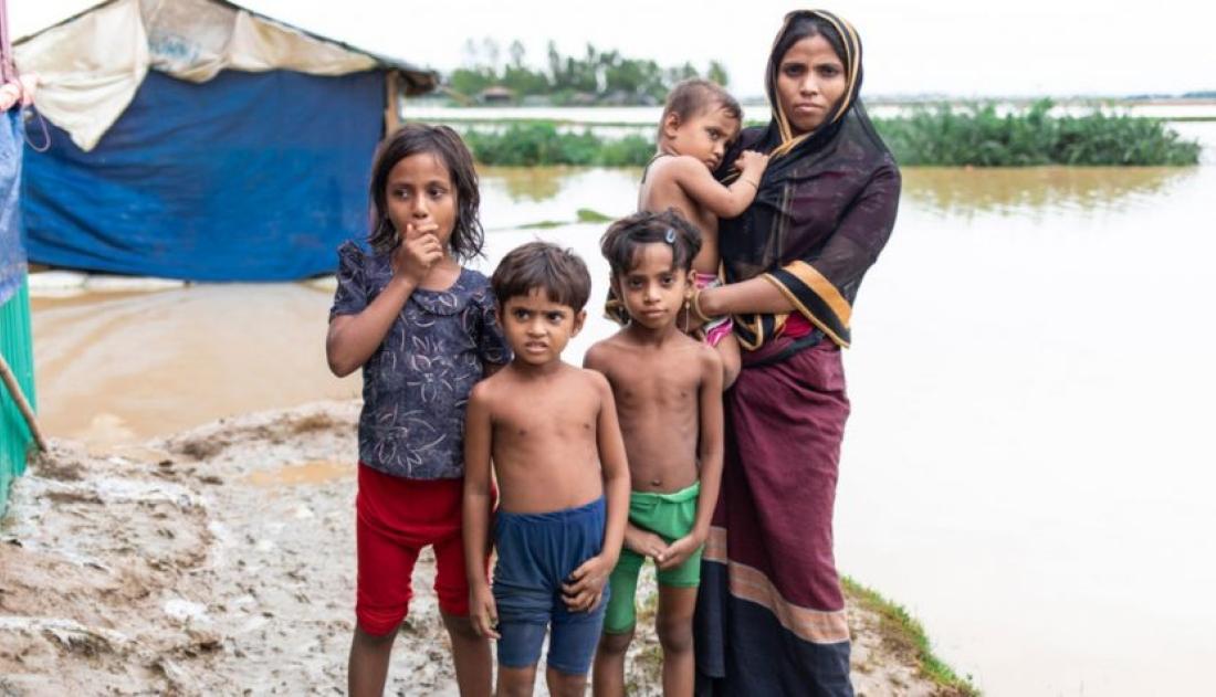 A family standing near a flooded lake