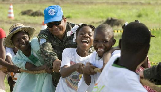 Members of the Brazilian battalion of the UN Stabilization Mission in Haiti (MINUSTAH) play tug of war with a group of local children during a civic day event in Cité Soleil, Haiti. UN Photo/Logan Abassi