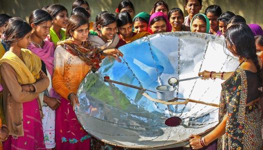 UNDP India In India, a woman demonstrates how to use a solar dish for cooking.
